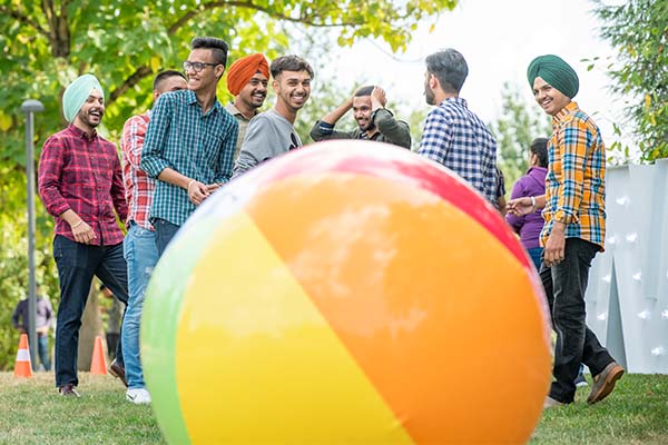 Students playing on a campus green with an inflatable ball